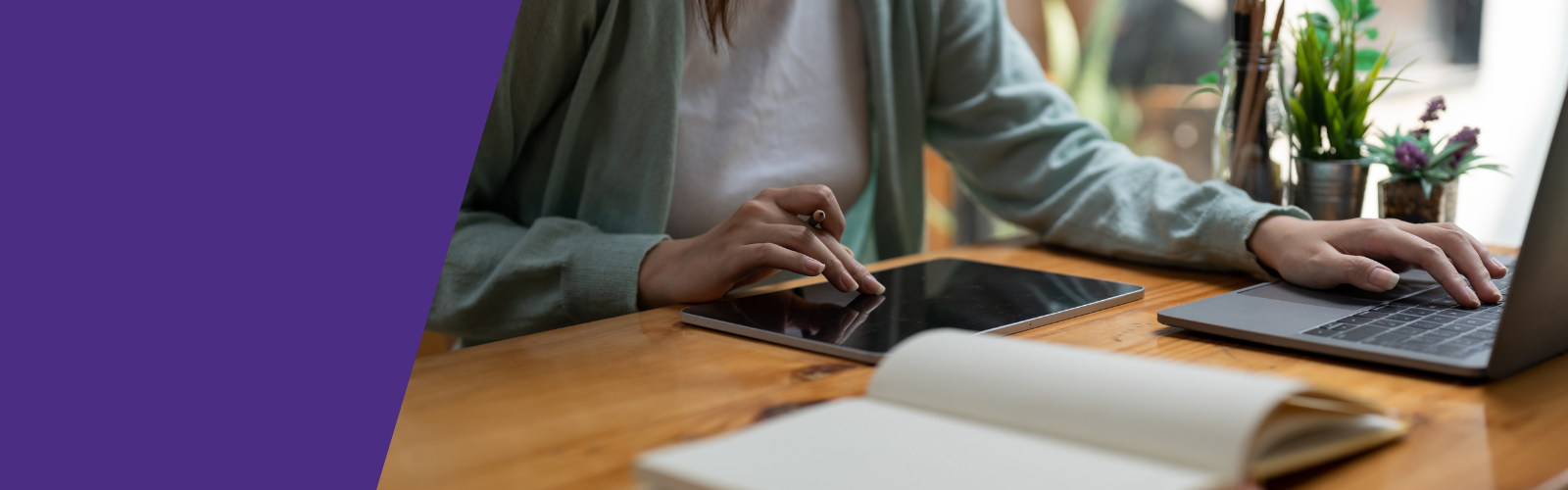 Photo of a woman working on a laptop and tablet